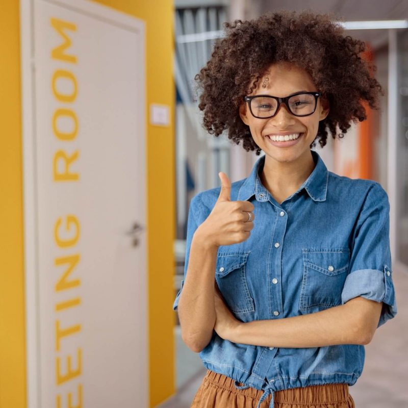 multiethnic-young-lady-holding-thumb-up-in-coworking.jpg